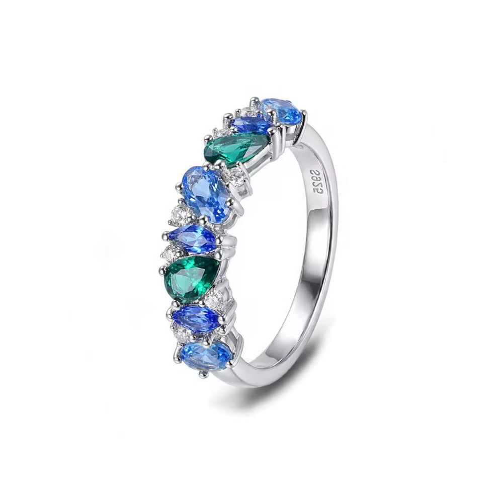 A silver-colored ring featuring a curved row of marquise-cut gemstones in shades of blue and green, accented with small clear stones, shown on a white background.