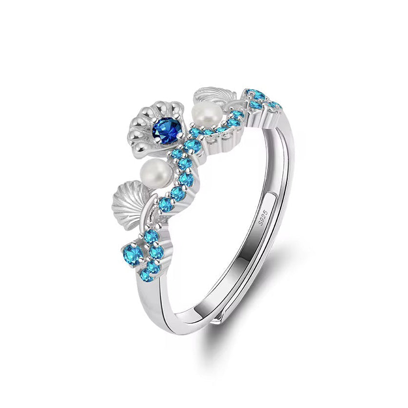 Silver ring with blue gemstones and pearls on a white background, featuring 'Real Sterling Silver' stamp.