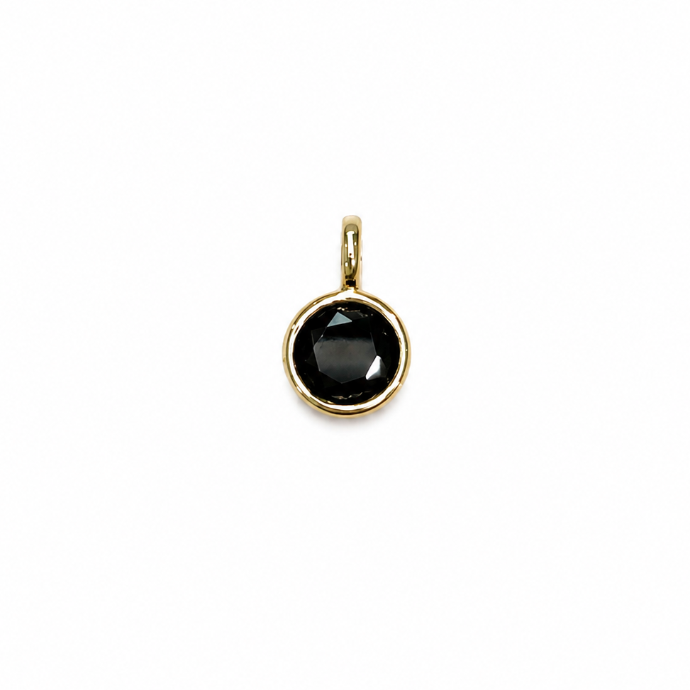 A small round black gemstone pendant in a gold bezel setting, centered on a plain white background.
