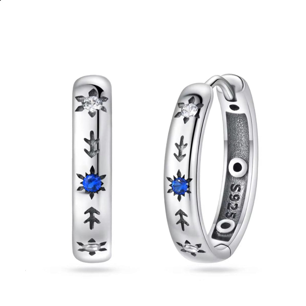 Silver hoop earrings with blue gemstones on a snow white background