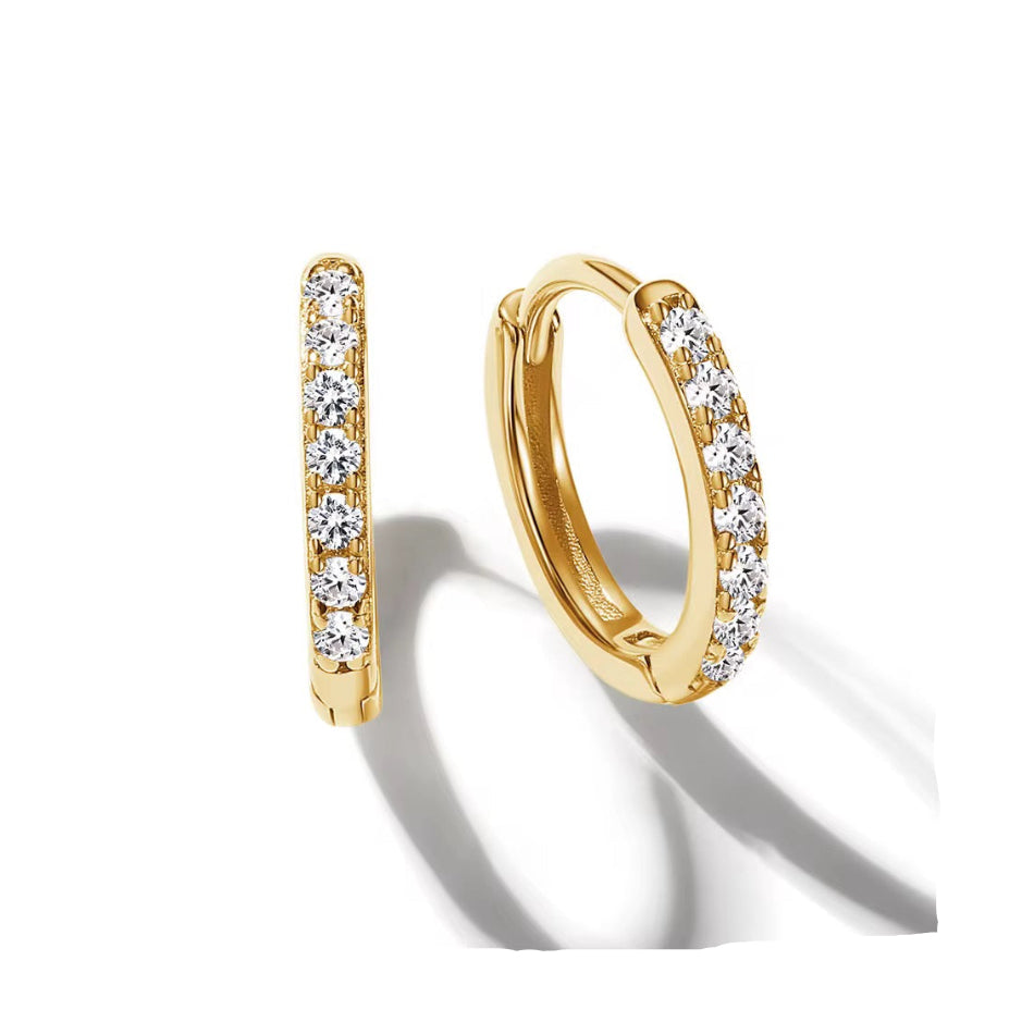 Gold hoop earrings with clear gemstones on a white background