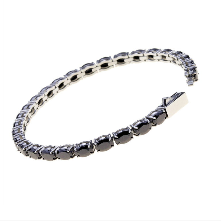 A silver tennis bracelet featuring black polished oval gemstones in a classic link style, shown on a plain white background.