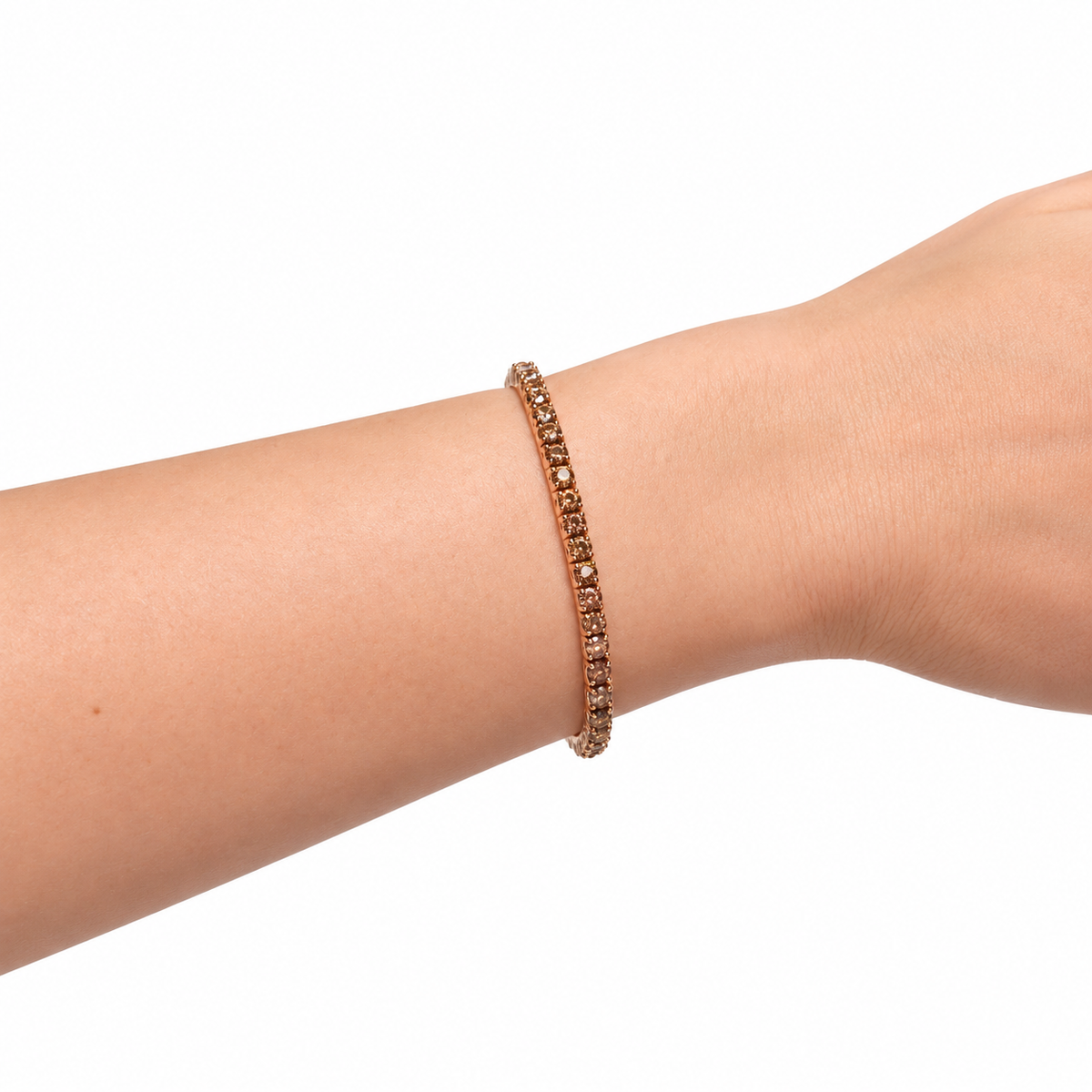 rose gold tennis bracelet with small champagne stone, worn woman's wrist in white background