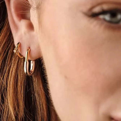 Close-up of two-tone Sterling Silver and 14k Gold-Plated earrings, featuring rhodium accents and stylish hoops.