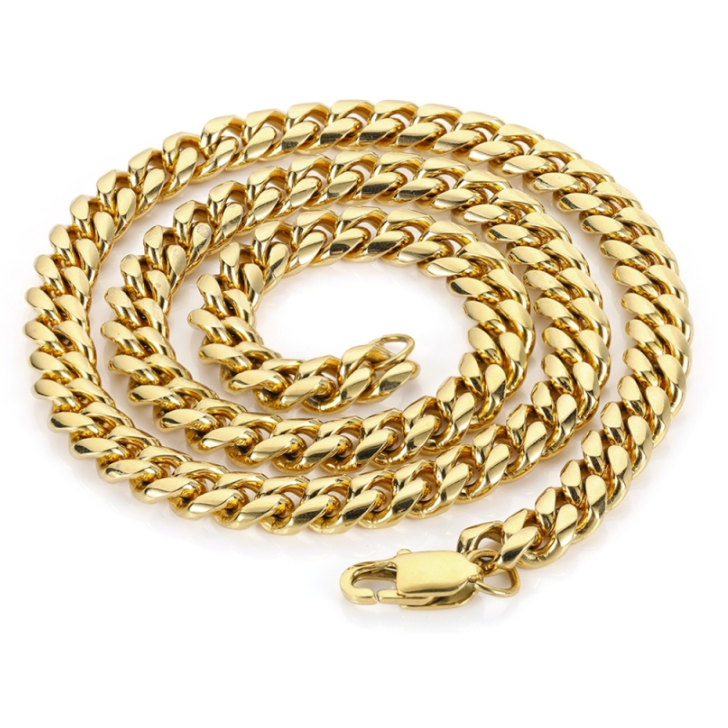 A gold-toned Cuban link chain necklace coiled on a white background, featuring a lobster clasp closure.