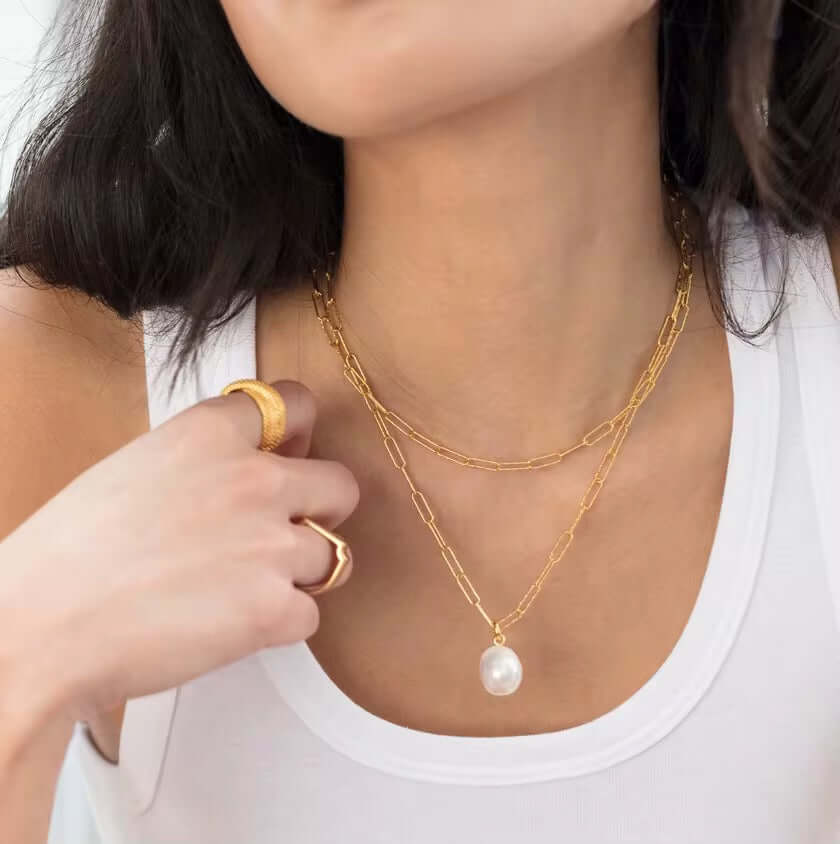 Stylish model wears a 925 Sterling Silver and 14k Gold-Plated necklace with a large freshwater pearl, showcasing elegance and charm.