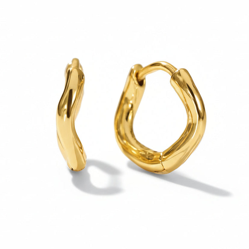 Irregular shaped huggies in 925 sterling silver with 14k gold-plated finish, perfect for elegant style. Rhodium plated for durability.