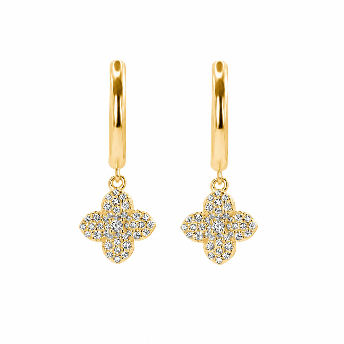 A pair of gold huggie hoop earrings with dangling four-flower clover motifs paved with clear stones, shown on a solid white background.