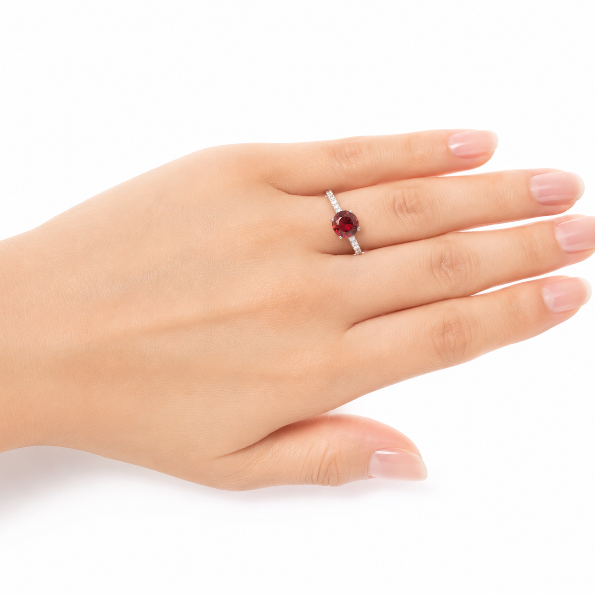 Sterling silver ring with a natural round red garnet-style stone and sparkling side stones, worn on a woman's hand