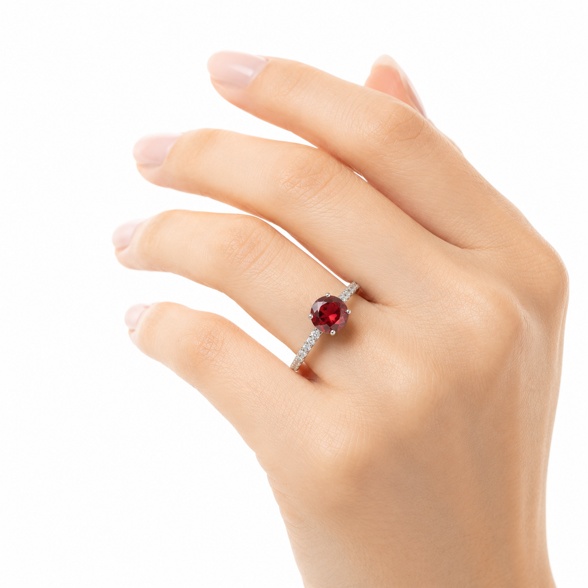 Sterling silver ring with a round red garnet-style stone and sparkling side stones, worn on a woman's hand