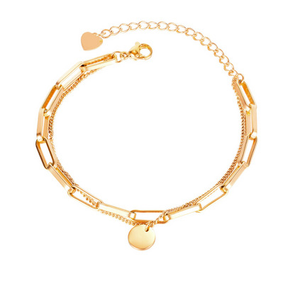 A gold-plated chain bracelet with alternating rectangular and chain links, featuring a small round disc charm and a small heart charm, displayed on a clean white background.